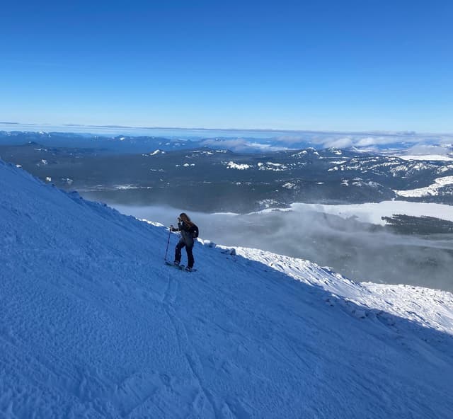 Two skiers riding down a snowy mountain slope together